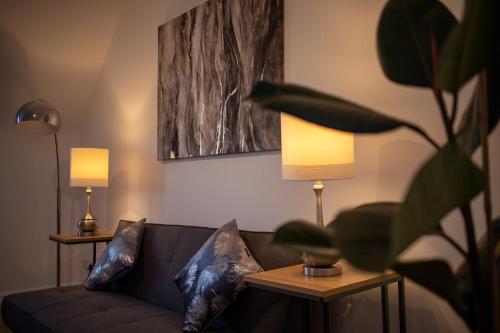 a living room with a couch and two lamps at Historic, City Centre Apartment in Aberdeen