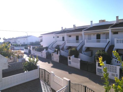 una fila de edificios de apartamentos blancos con una valla en Alpen1 Peñismar II, en Peñíscola