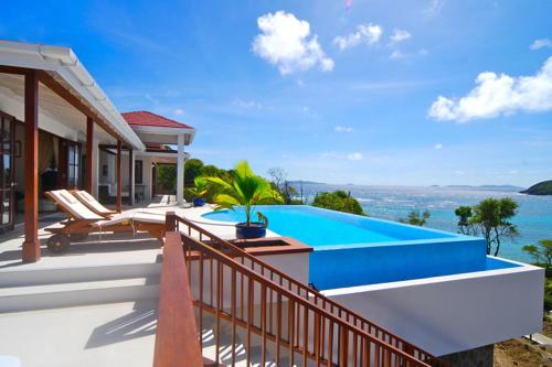 a house with a swimming pool on a balcony at IJEOMA HOUSE in Bequia