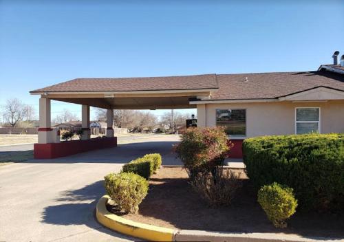 ein Gebäude mit einem Pavillon mit Büschen davor in der Unterkunft Executive Inn Woodward in Woodward