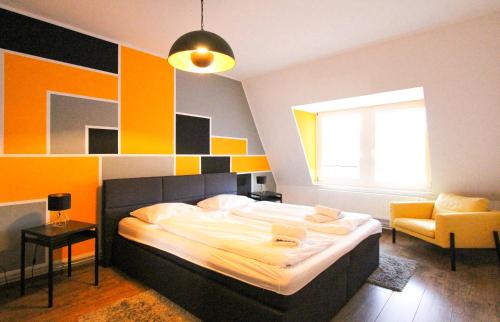 ein Schlafzimmer mit einem großen Bett und einem Stuhl in der Unterkunft Cozy Domicile Leipzig Center South I in Leipzig