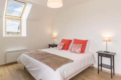 a bedroom with a white bed with red pillows at La Ferme de Presles in Menainville