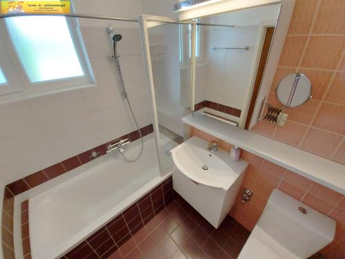 a bathroom with a sink and a shower and a toilet at Apartment Nah Dran by FiS - Fun in Styria in Bad Mitterndorf