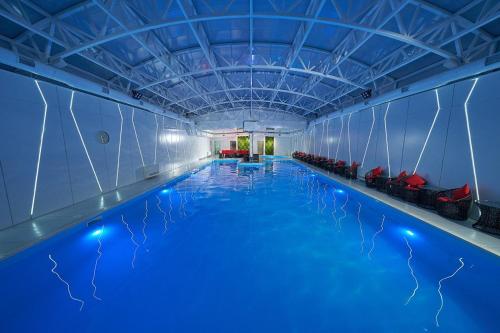 una grande piscina coperta con illuminazione blu di Dream Hotel a Izmaïl