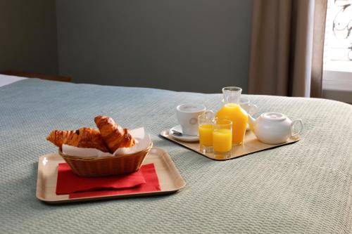 a breakfast of croissants and orange juice on a table at Le Grand Albert 1er in Maisons-Alfort