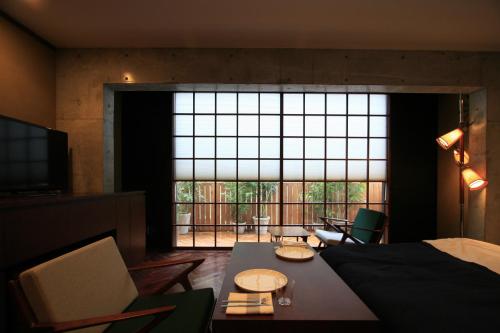 Habitación con cama, mesa y ventana grande. en Studio-D en Tokio