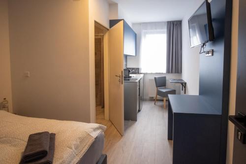a room with a bed and a kitchen with a desk at Hotel A24 bei Hamburg in Glinde