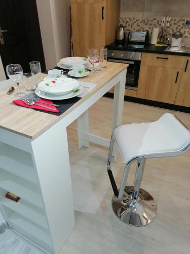 a white table with a white chair in a kitchen at Data Central Studio in Novi Sad