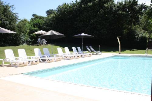una piscina con tumbonas y sombrillas en Paulanosa Gite, en Asnières-sur-Vègre