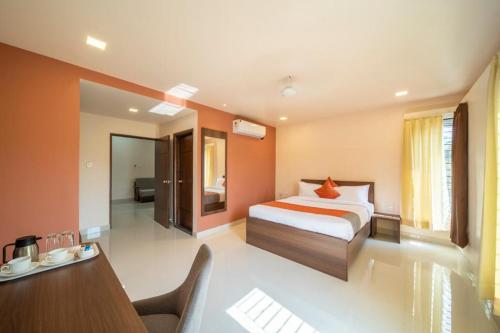 sypialnia z łóżkiem i biurkiem w pokoju w obiekcie Elys'ees Serviced Suites w mieście Bengaluru