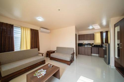 sala de estar con sofá y mesa en Elys'ees Serviced Suites, en Bangalore