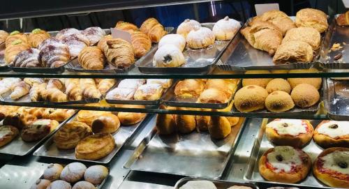 eine Vitrine mit vielen verschiedenen Arten von Gebäck in der Unterkunft Grand Tour Design Guest House Catania Self Check-in in Catania