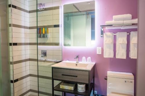 a bathroom with a sink and a glass shower at The Arts Hotel in Charlottetown