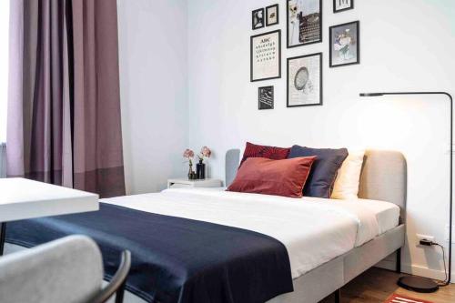 a bedroom with a large white bed with red pillows at Beautiful Studio - Top Location - Netflix in Bucharest