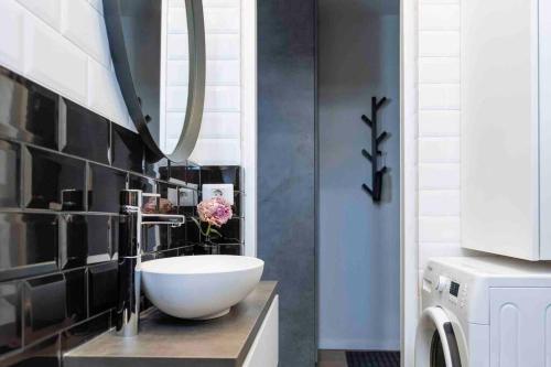 a bathroom with a bowl sink and a mirror at Beautiful Studio - Top Location - Netflix in Bucharest
