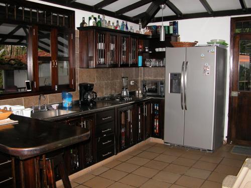 a kitchen with a white refrigerator and wooden cabinets at Casa de la Ciencia in Salento