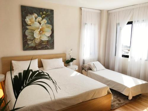 a bedroom with two beds and a painting on the wall at Apartment VIParaiso in Adeje