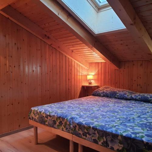 a bedroom with a bed in a room with wooden walls at Casa Penia 2 in Canazei