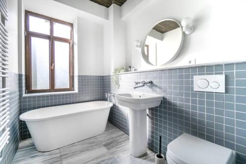 a bathroom with a tub sink and a toilet at Marvellous Design 2Br Old Town in Bucharest