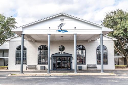 a white building with a dolphin on the front at Lake View Inn in Granbury