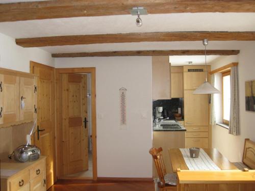 een keuken met houten kasten en een tafel. bij Casa Zupada/Wegmüller in Lenzerheide