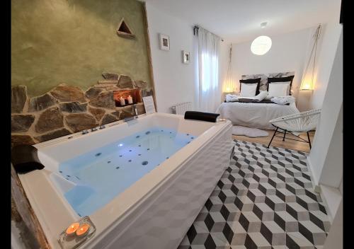 uma grande banheira de hidromassagem numa sala com um quarto em Alojamientos Segóbriga Rural ( Mandil) em Segorbe