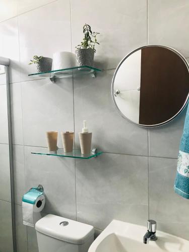 a bathroom with a mirror and a toilet and a sink at Aconchego na Capital do Forró - Térreo in Caruaru
