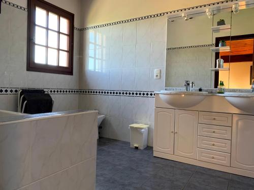 a bathroom with a tub and a sink and a mirror at Location d'une maison typique du Pays Basque in Caro