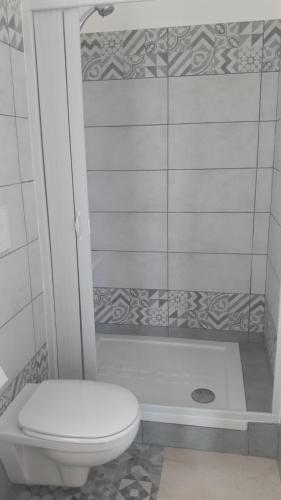 a white bathroom with a toilet and a shower at La stanza del paradiso in Torre Pali 