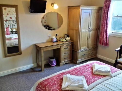 a bedroom with a bed and a dresser at Crow Park Hotel in Keswick
