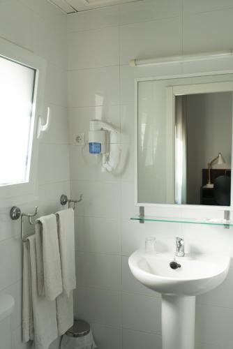 a white bathroom with a sink and a mirror at Hotel Madrid de Sevilla by SHS in Seville