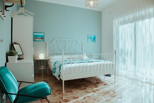 a blue bedroom with a bed and a chair at SoStanza - Rooms in Catania in Catania