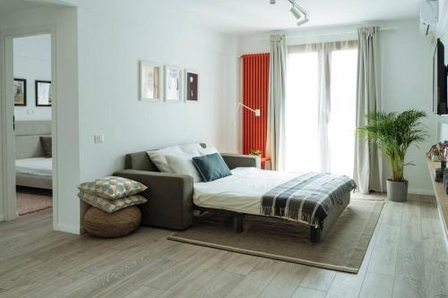 una sala de estar con una cama y un sofá en Sunny 2BR Flat - Old Town View, en Bucarest