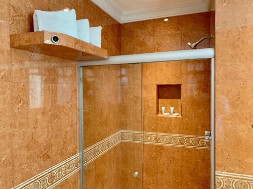 uma casa de banho com um chuveiro e uma cabina de duche em vidro. em Hotel Nilo em Acapulco
