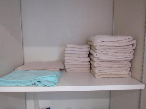 two stacks of towels sitting on a shelf in a bathroom at Amami Lucky House - Vacation STAY 07619v in Amami