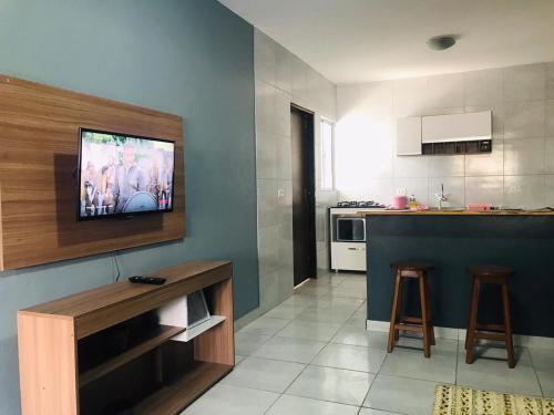 uma cozinha com uma televisão de ecrã plano na parede em Aconchego na Capital do Forró - Térreo em Caruaru