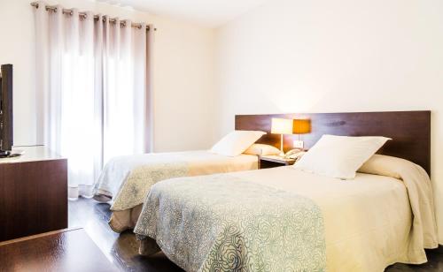 a bedroom with two beds and a window at Hotel Madrid de Sevilla by SHS in Seville