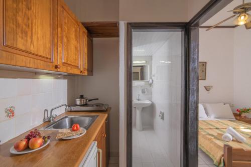 a kitchen with a sink and a bathroom with a bed at Iliostasi Beach Apartments in Hersonissos