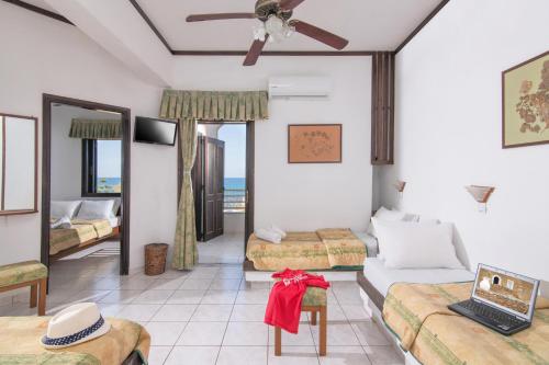 um quarto de hotel com duas camas e uma varanda em Iliostasi Beach Apartments em Hersonissos