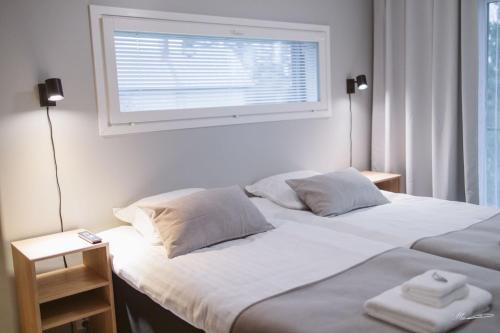 - une chambre avec un grand lit blanc et une fenêtre dans l'établissement Villa Veromäki, à Vantaa