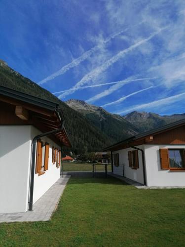 a view of a building with mountains in the background at BergAufe Chalets Mallnitz in Mallnitz