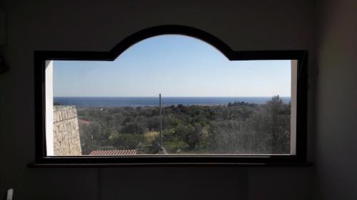 a window in a room looking out at the ocean at La stanza del paradiso in Torre Pali 