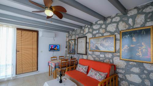 een woonkamer met een bank en een plafondventilator bij Teras butik apart in Karaburun