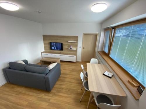 a living room with a couch and a table at Hotel U Kabinky in Janske Lazne