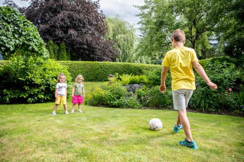 two children playing with a soccer ball in a yard at Kaiserhoam in Söll