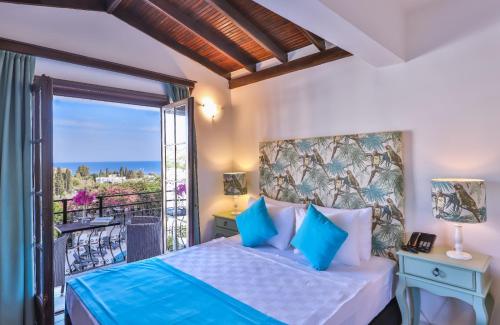 een slaapkamer met een bed en een balkon bij Mare Garden Hotel in Akyarlar