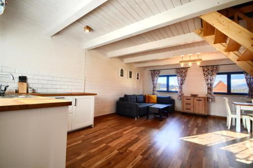 a kitchen and living room with a couch and a table at Siedlisko Leśnica - domki całoroczne Brenna in Brenna