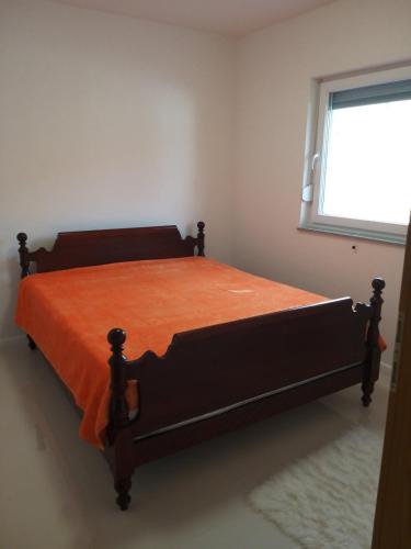 a bed in a bedroom with an orange blanket on it at COUNTRY HOUSE in Bihać