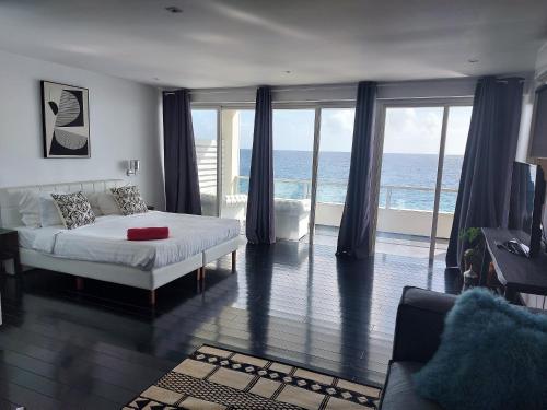 a bedroom with a bed and a view of the ocean at Saint Tropez Boutique Hotel in Willemstad