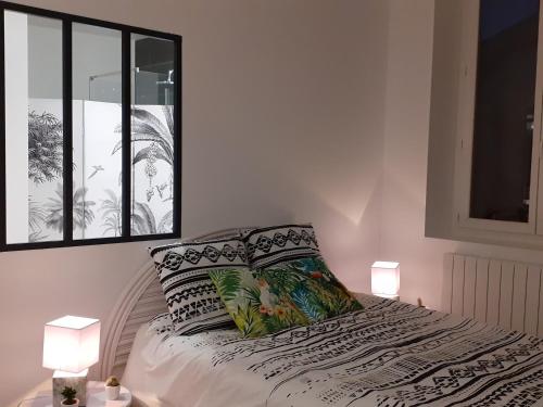 - une chambre avec un lit, deux lampes et une fenêtre dans l'établissement Tropical loft, au Puy-en-Velay